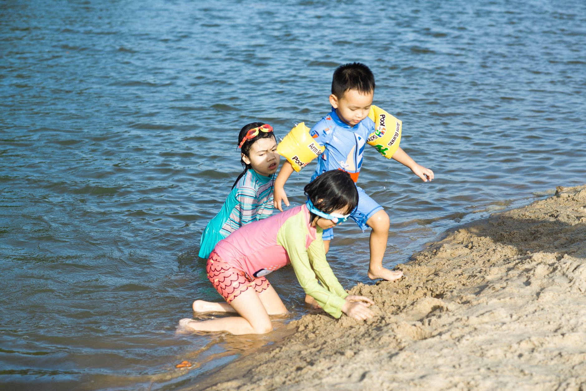 Kids enjoying a sunny day at the beach in Vũng Tàu, Việt Nam, building sand castles.