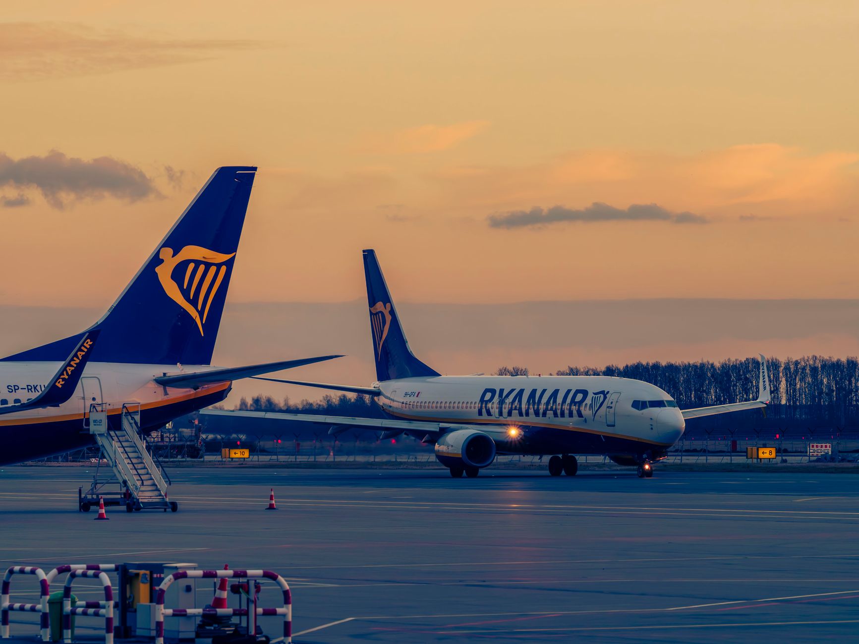 Ryanair airplanes parked at sunset in Wrocław Airport, Poland, showcasing a serene evening atmosphere.