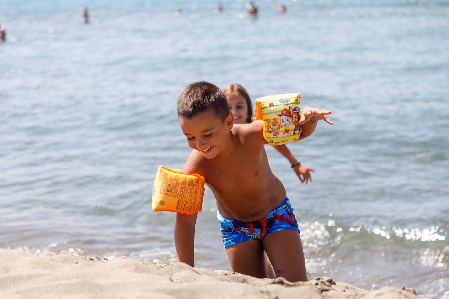 Joyful children enjoying a sunny day at the beach in Ulcinj, Montenegro.
