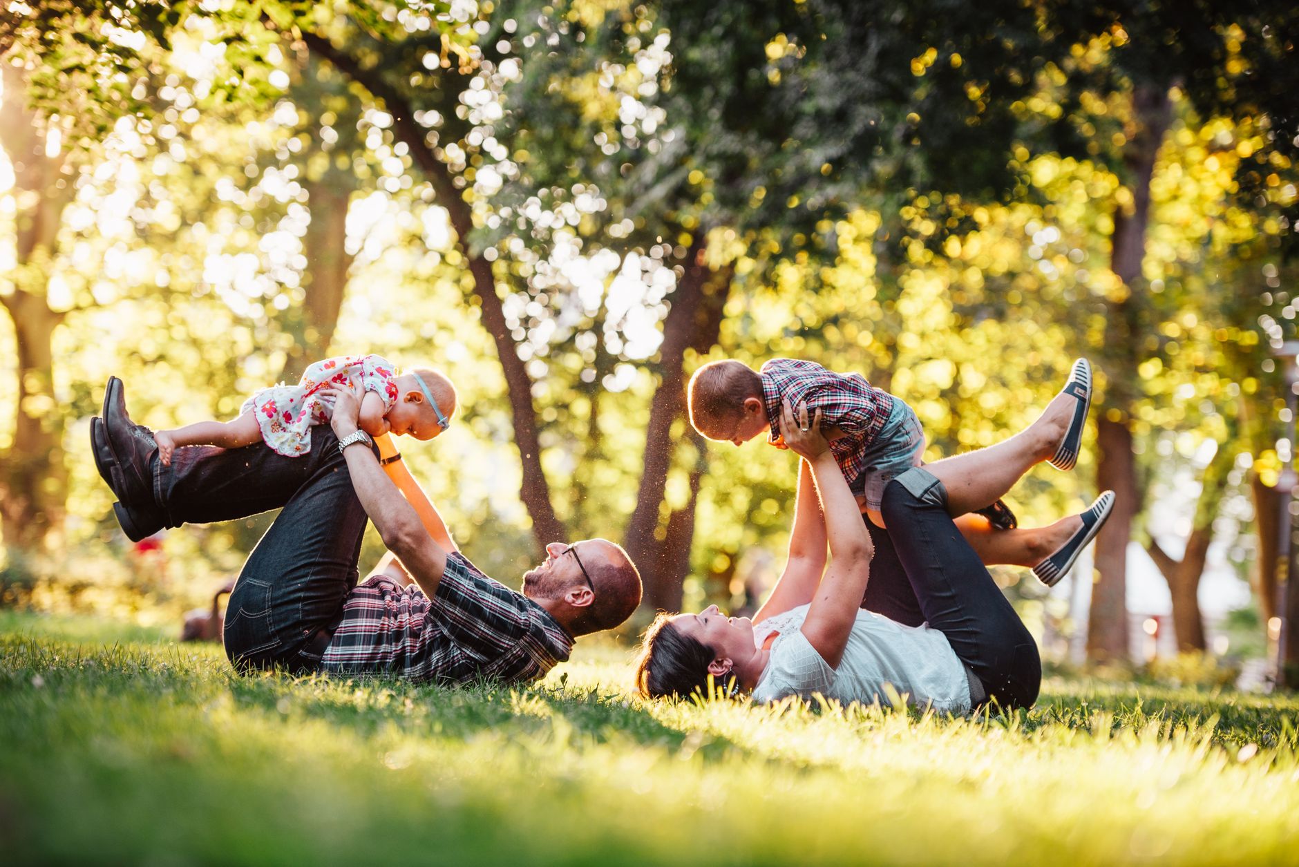 A joyful family enjoying playtime in a sunny park, capturing moments of laughter and happiness.