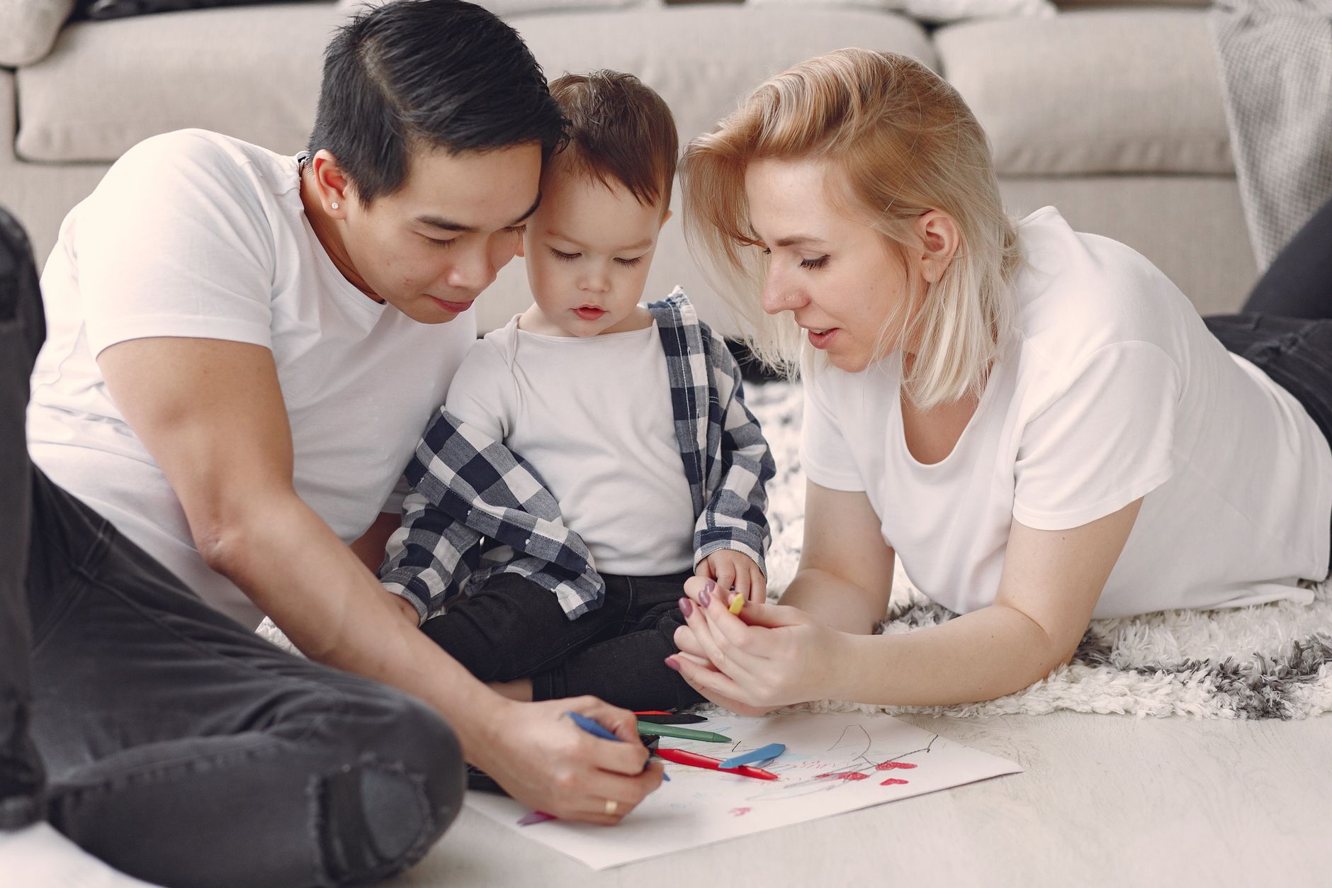Loving family creating art together, fostering play and connection indoors.