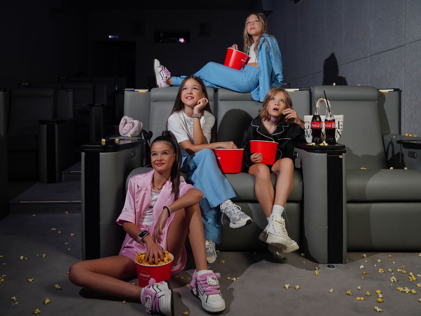 Group of girls watching a movie in a cinema with snacks.