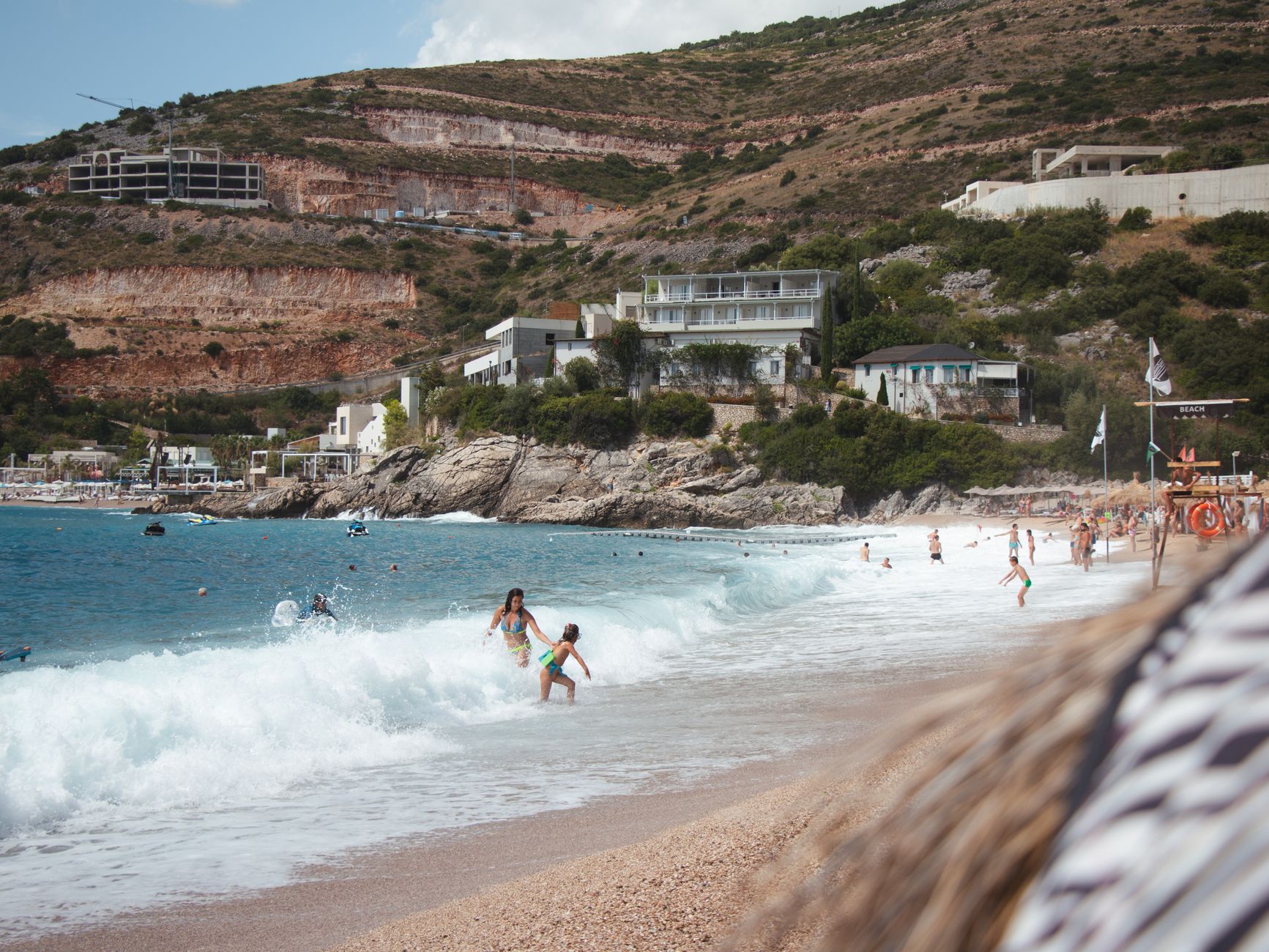Families enjoy a vibrant summer day at the beach in Vlorë County, Albania.