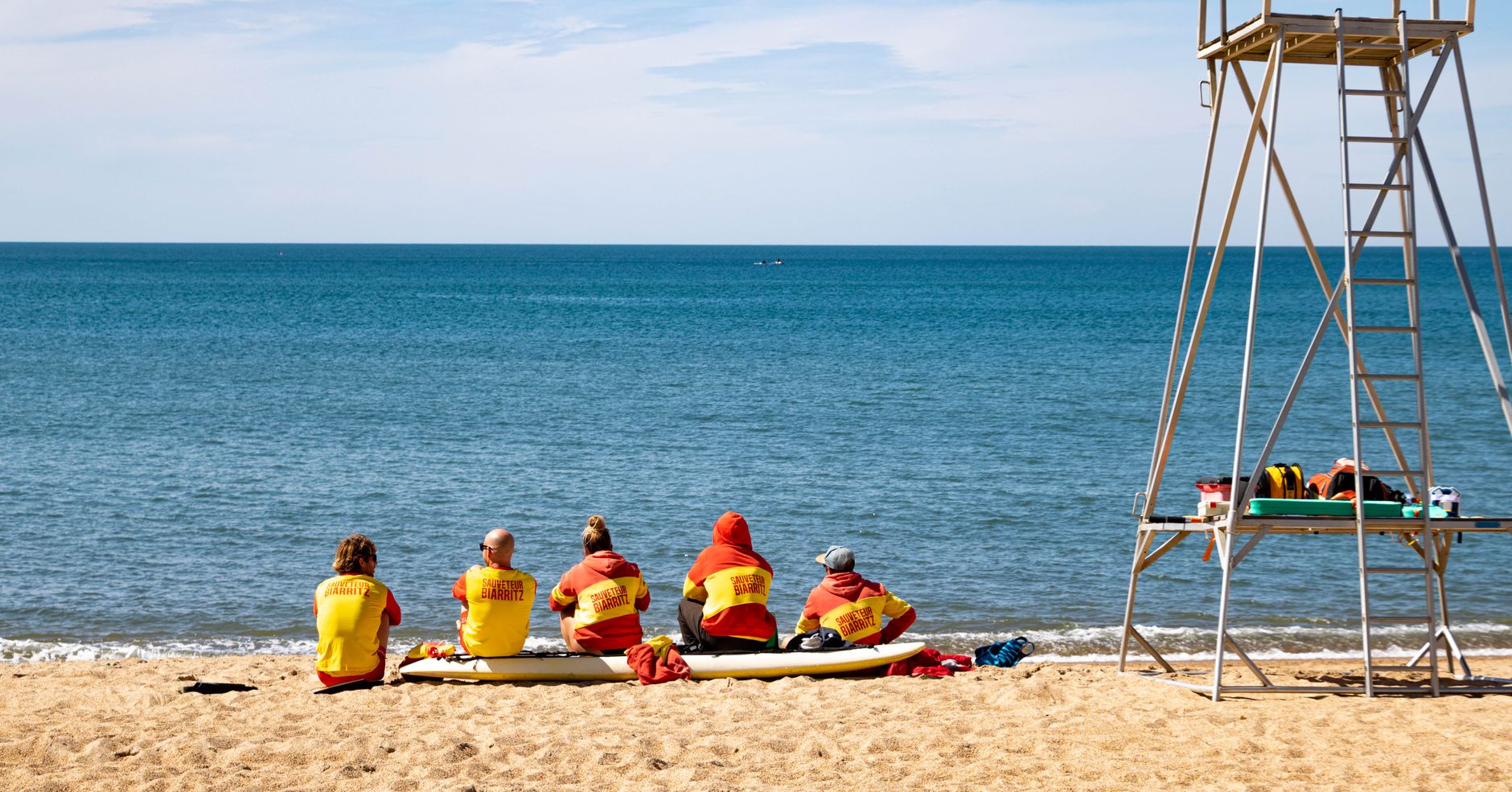Vibrant scene of lifeguards on a sunny day at Biarritz beach, France, ensuring safety.