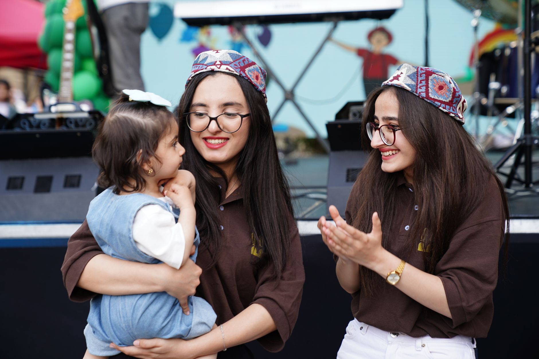 Happy family enjoying an outdoor festival with music, dancing, and cultural celebration.