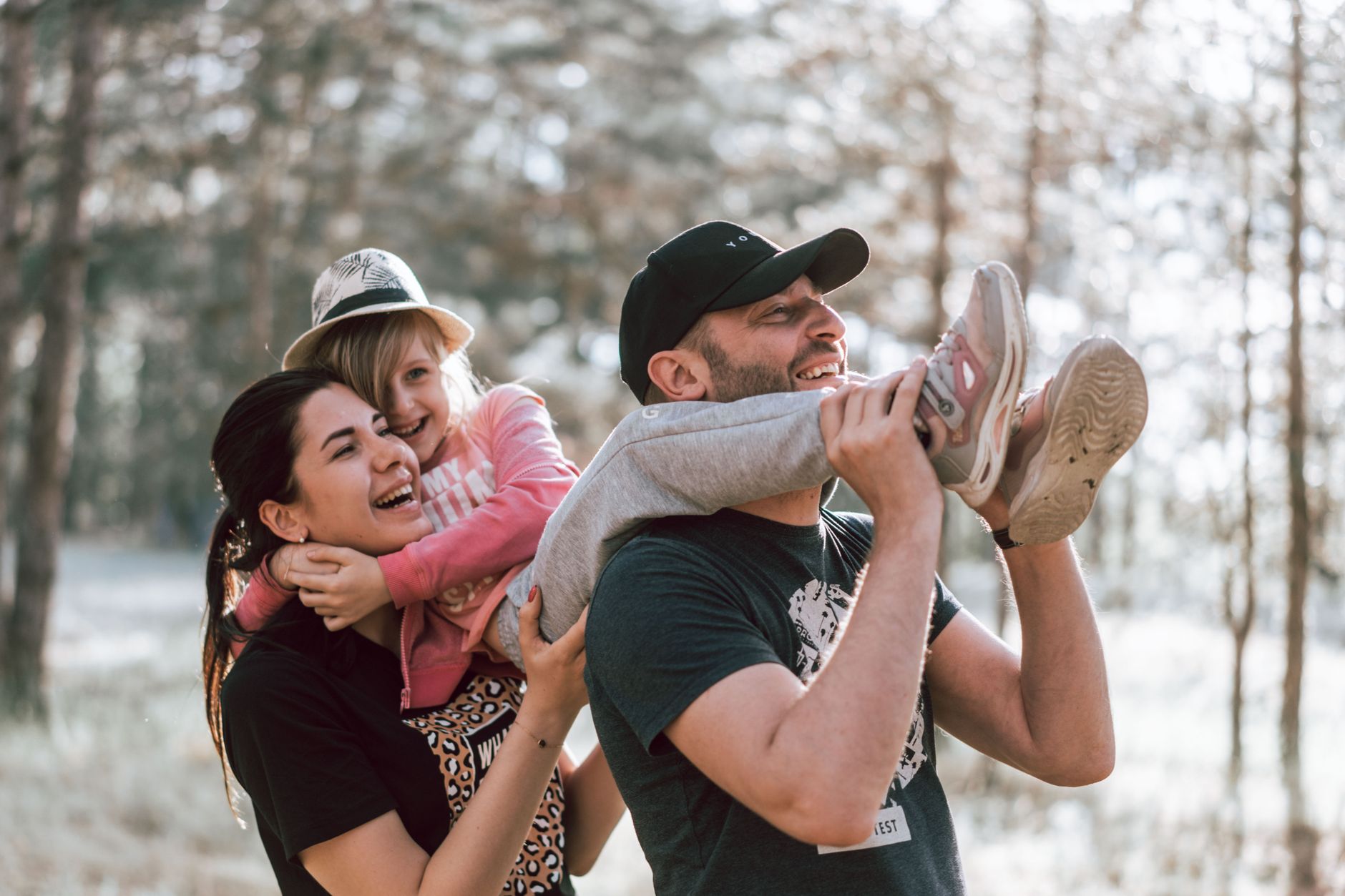 Happy family having fun in a forest, capturing joyful bonding moments.