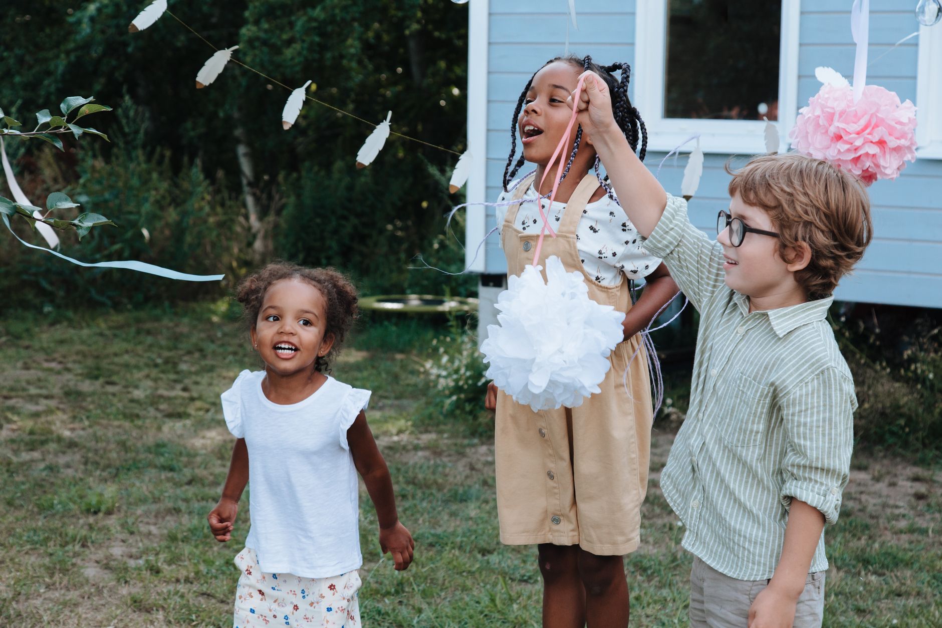Children celebrating outdoors, enjoying a festive event with decorations.