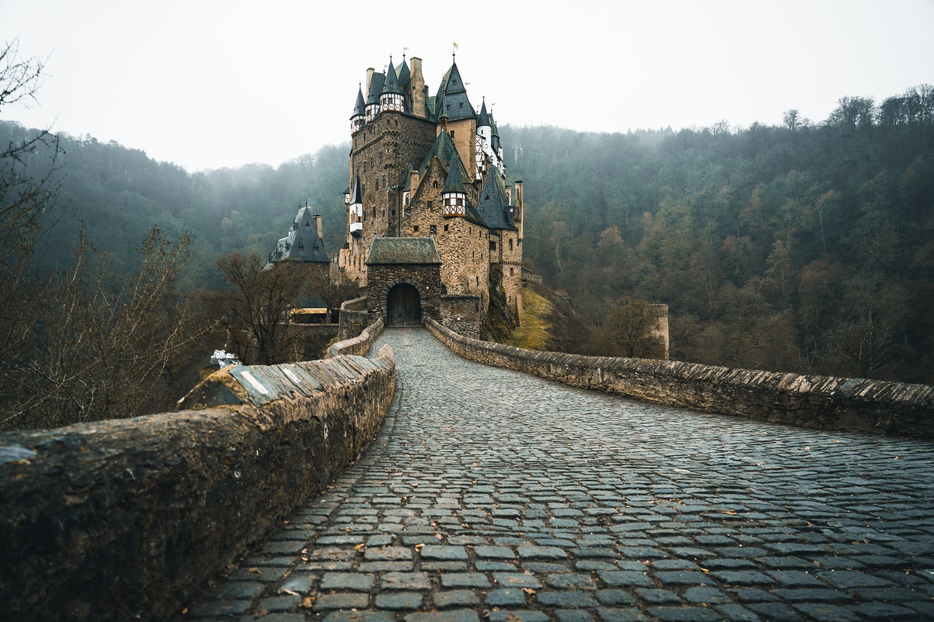 Discover the mystical allure of Eltz Castle amidst a foggy autumn forest in Germany.
