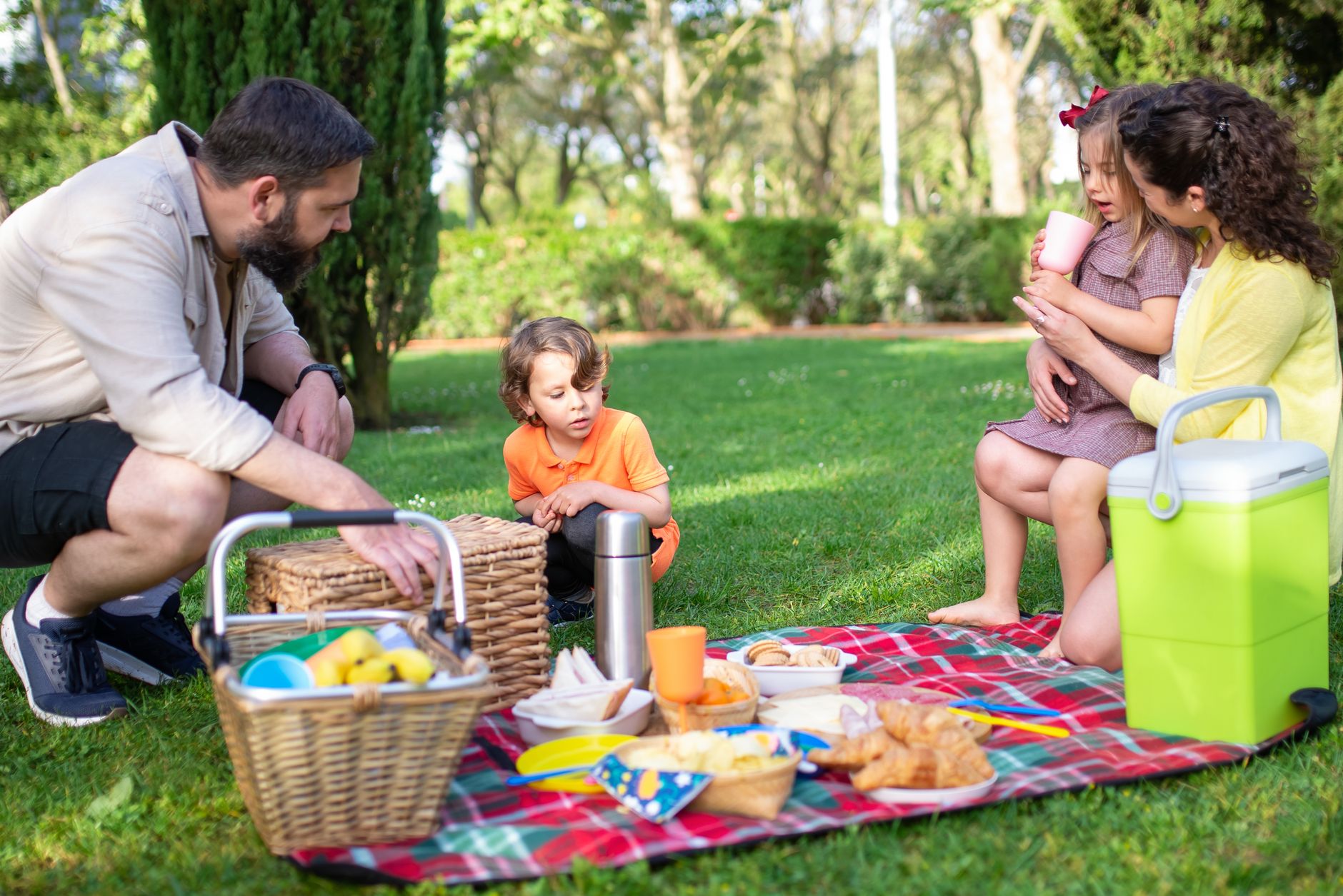 A joyful family picnic in a Portugal park, featuring adults and children enjoying outdoor leisure on a sunny day.